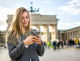 Schönes blondes junges Mädchen telefoniert vor Brandenburg