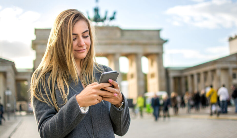 Schönes blondes junges Mädchen telefoniert vor Brandenburg