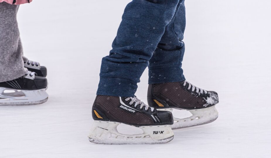 Nahaufnahme von zwei Personen mit Schlittschuhen auf dem Eis