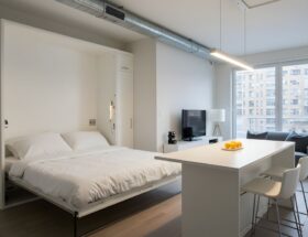 Helles Studio mit Klappbett, Küchenblock und Holzpaneelen – funktionale Gestaltung auf begrenztem Wohnraum