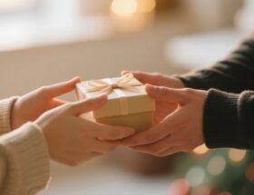 Zwei Personen überreichen sich ein schlicht verpacktes Geschenk – stellvertretend für bedeutungsvolle Aufmerksamkeiten wie individuell gewählte Partnerringe.