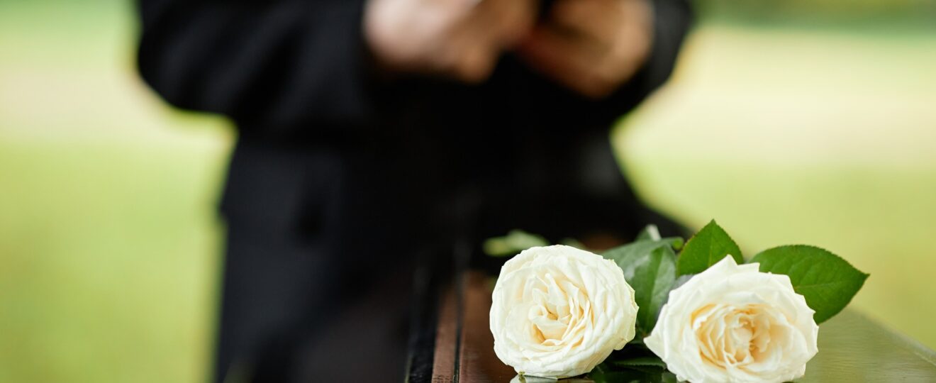 Weißer Rosenschmuck auf dunklem Sarg | Beerdigungen Hofheim