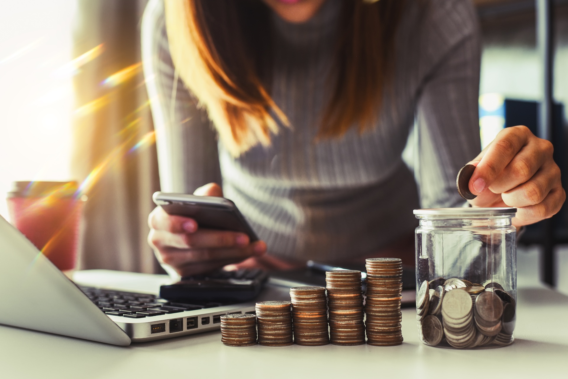 Frau zählt Münzen und prüft Budget am Handy | Elfbar Pods

