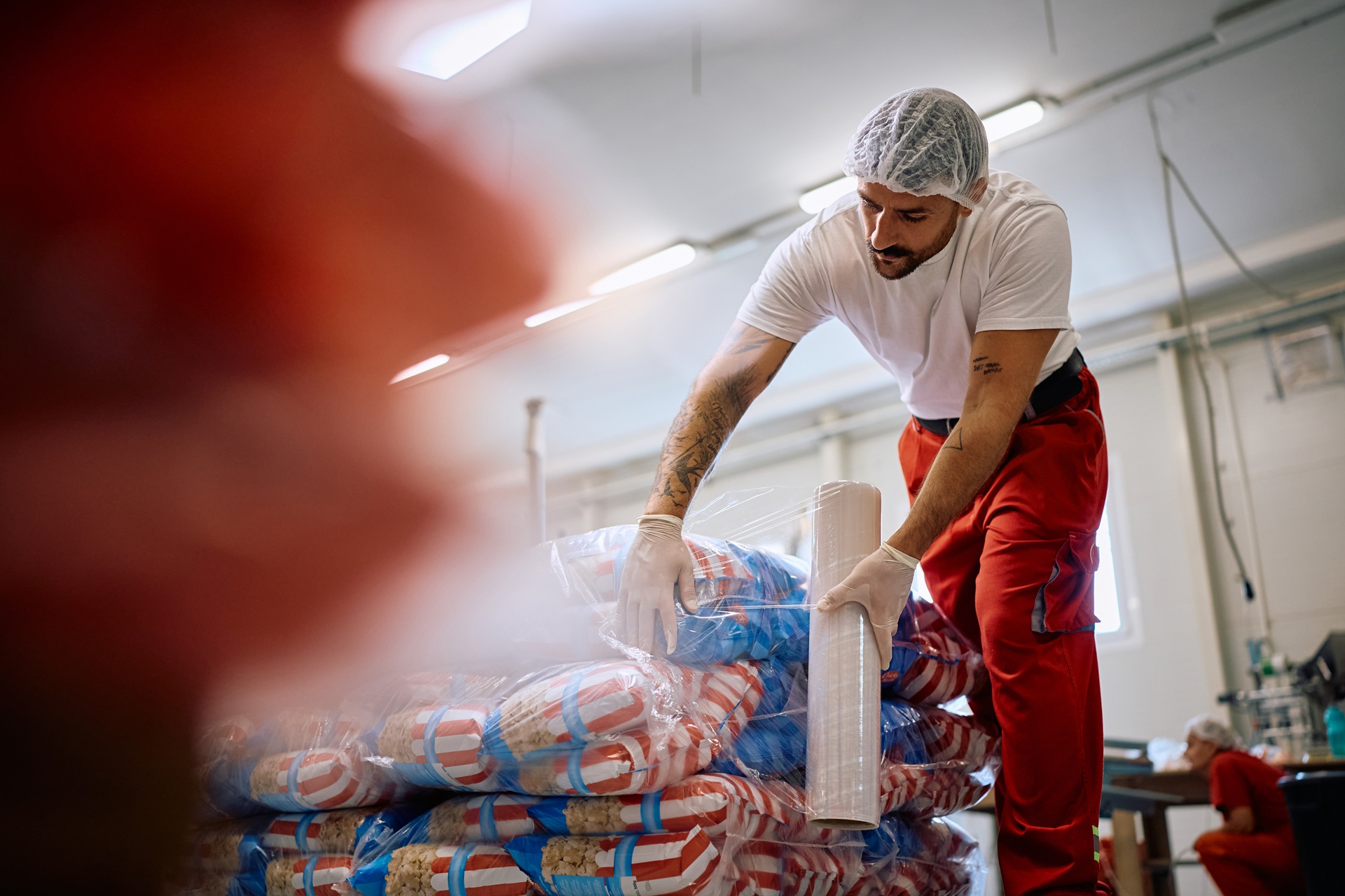 Arbeiter verpackt Lebensmittelware | Schlauchbeutelmaschine

