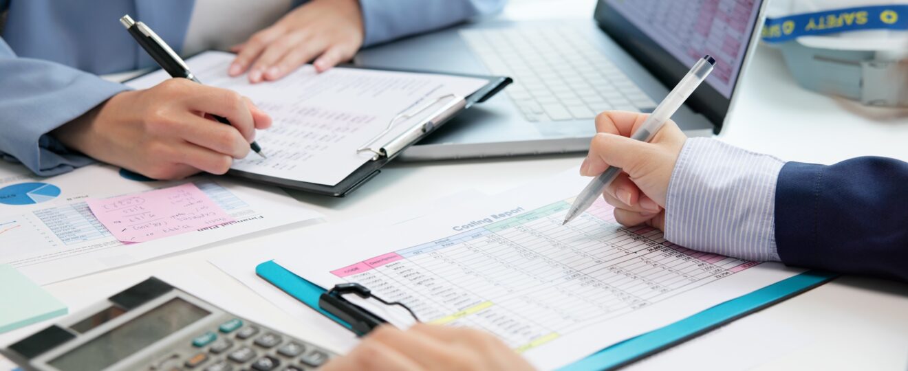 Team erstellt Kostenanalyse mit Tabellen und Laptop | Staubsauger Industrie