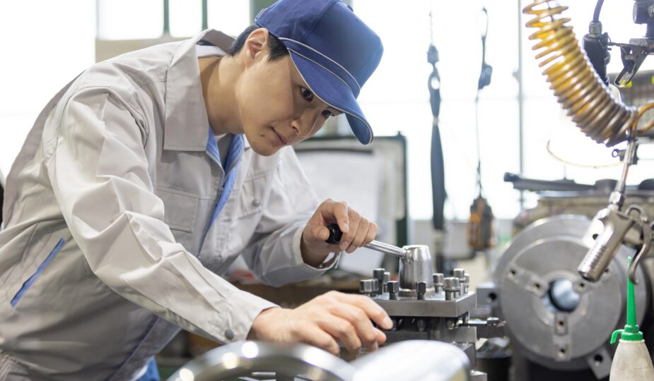 Industriemechaniker arbeitet konzentriert an Metallmaschine | Sandstrahlschlauch